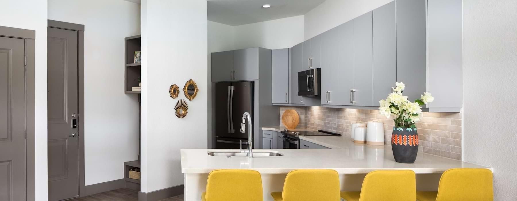 a kitchen with yellow chairs